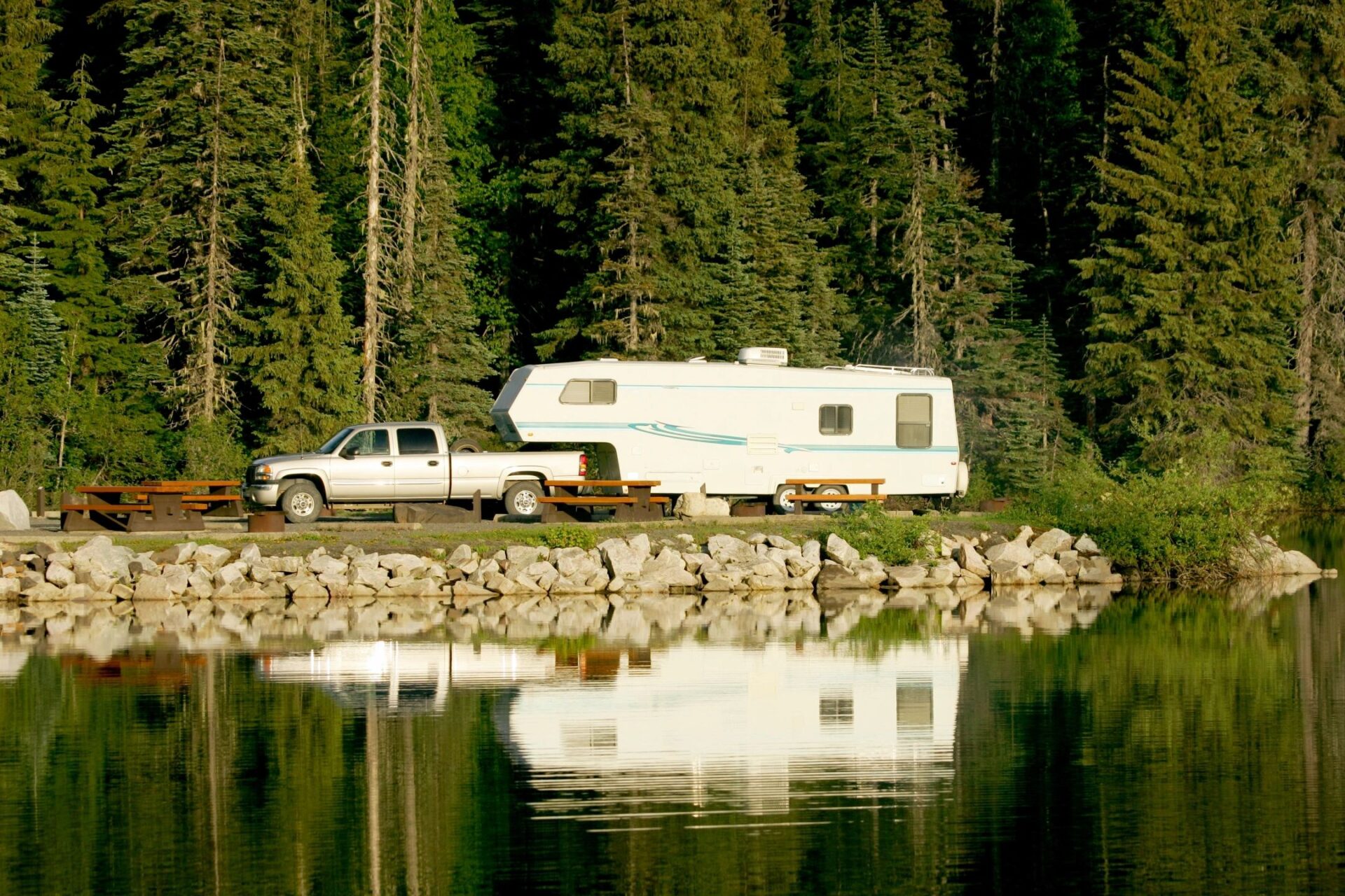 A truck parked next to a white trailer.