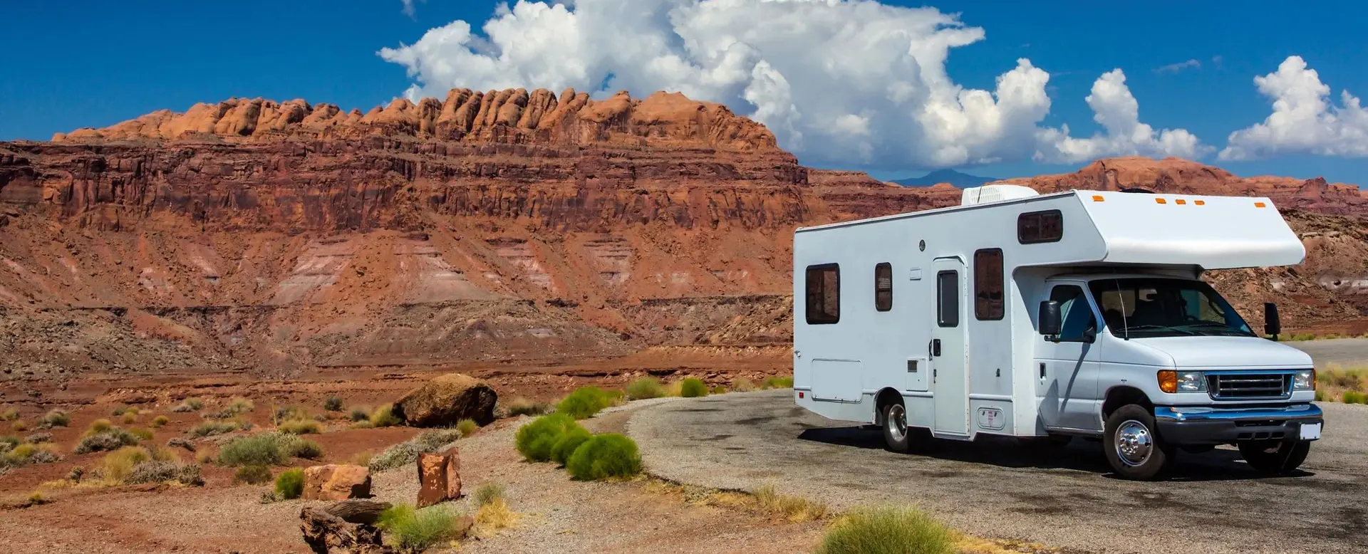 A white rv parked on the side of a road.