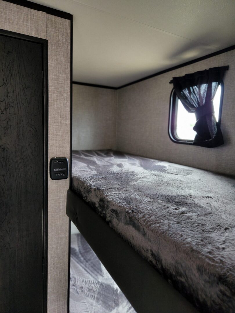 A bed room with a bunk bed and a window