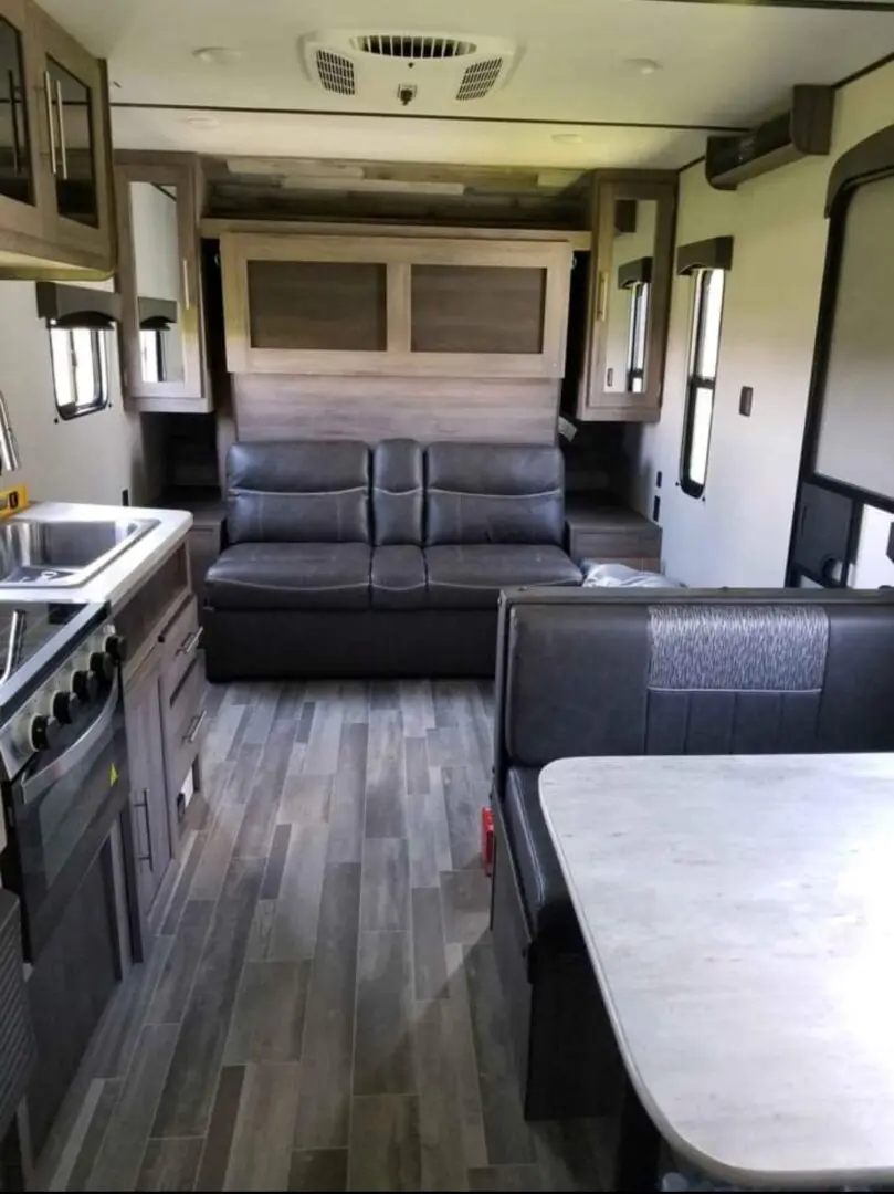 A couch and table in the back of an rv.